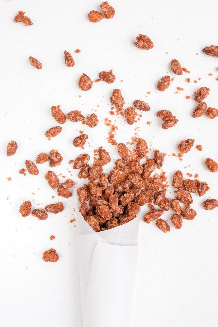 german candied almonds popping out of paper cone on white counter top