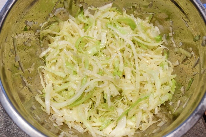 german coleslaw in mixing bowl with dressing