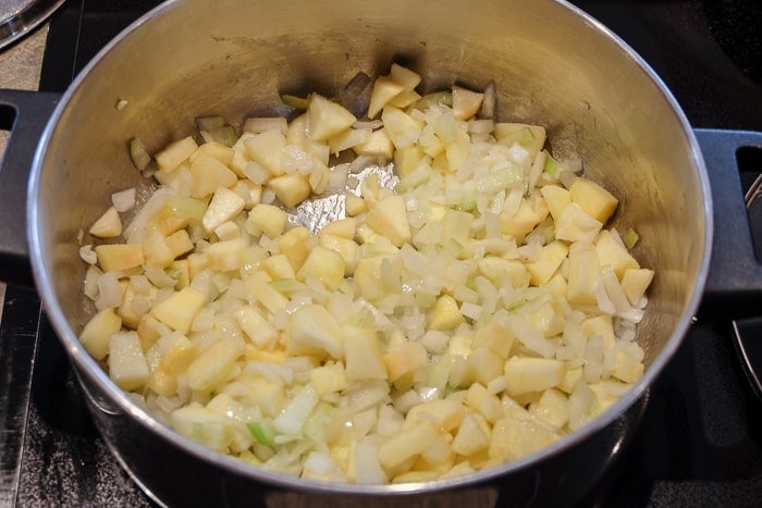 onions and apples frying in cooking pot