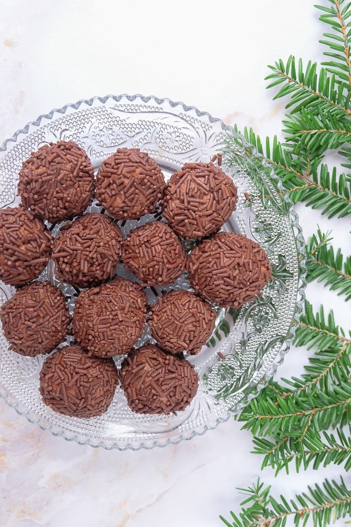 brown rum balls on clear plate with green beside