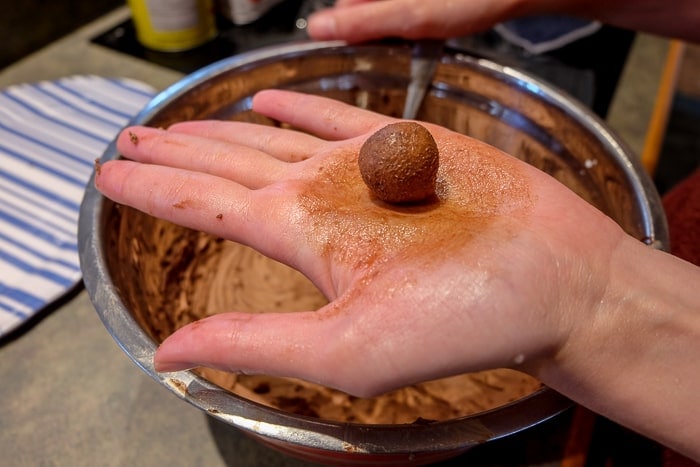 german rum ball rolled in hand over mixing bowl
