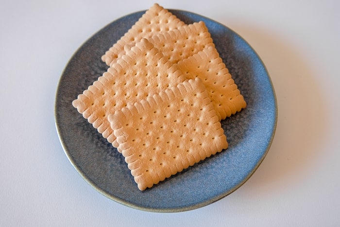 square butter biscuits on blue plate on white table