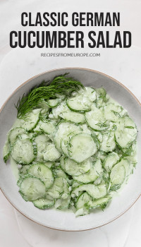 Slightly creamy cucumber salad in bowl on white background with text overlay saying classic German cucumber salad