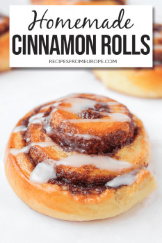 Cinnamon Rolls with white glaze on white surface with text overlay saying Homemade cinnamon rolls