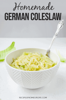 German cabbage salad in white bowl with spoon with text overlay saying homemade german coleslaw