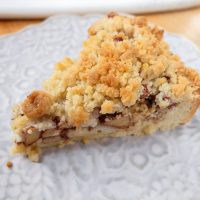 slice of german apple cake on plate with crumble on top