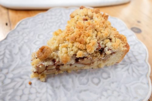 slice of german apple cake on plate with crumble on top