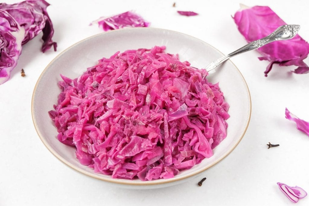 german red cabbage in bowl with spoon and cabbage around
