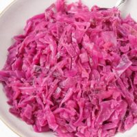 bowl of german red cabbage on white counter with silver spoon sticking out