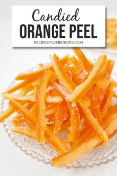 Photo of strips of candied orange peels on clear plate with text overlay saying candied orange peel