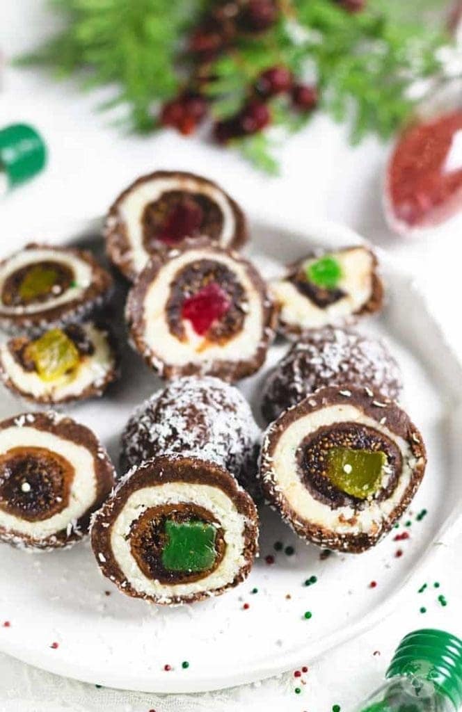 stuffed fig balls with coconut and chocolate cut open on white plate. 
