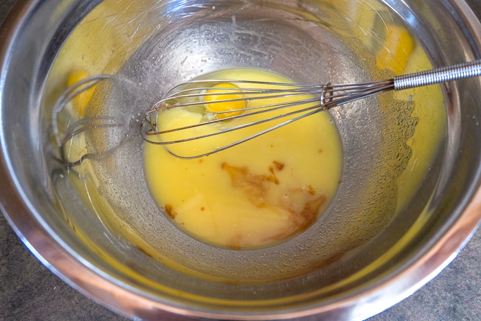 vanilla added into mixing bowl with whisk