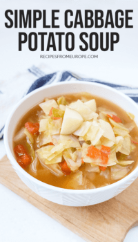 Photo of cabbage potato soup in bowl on wood cutting board with text overlay saying simple cabbage potato soup