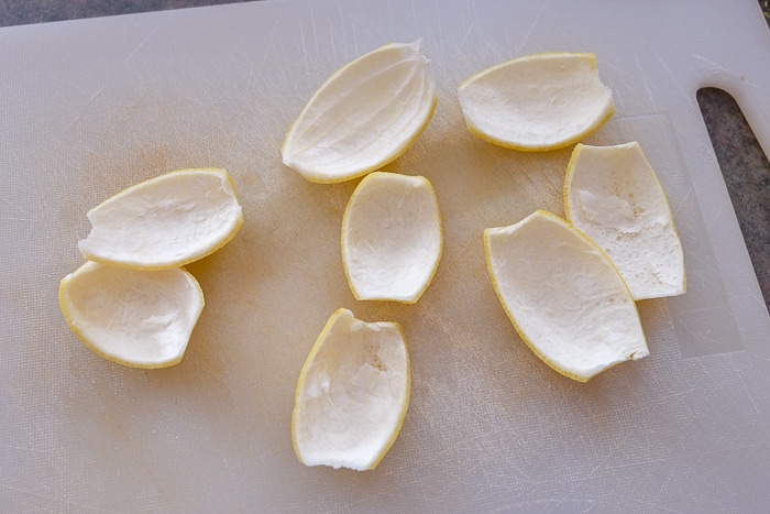 peeled lemon peels on white cutting board