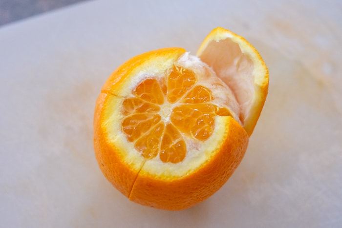 orange on cutting board with peel cut