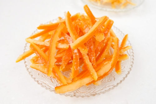 candied orange peel on clear plate on white counter