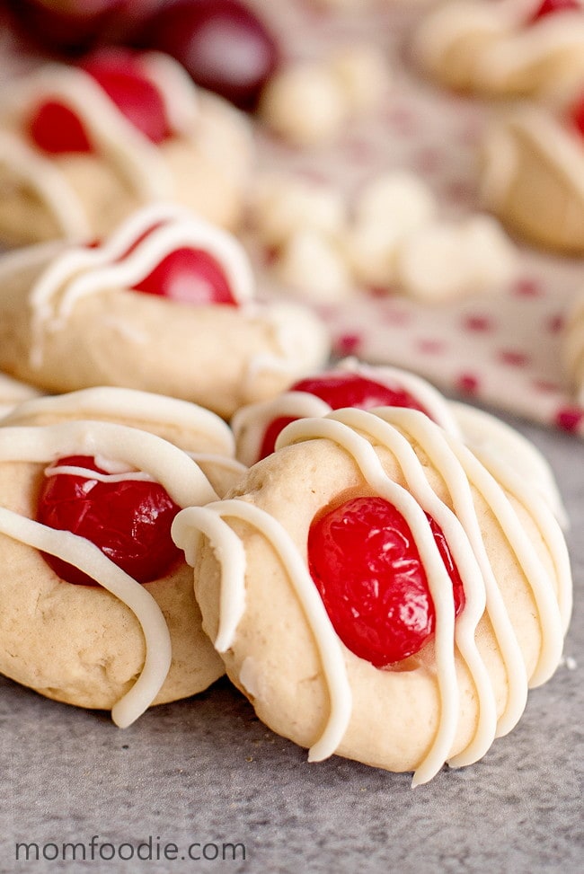 round cookies with cherry in middle and stripes of icing on top.