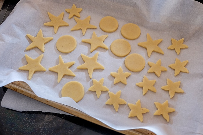 butter cookies in different shapes on parchment paper in pan