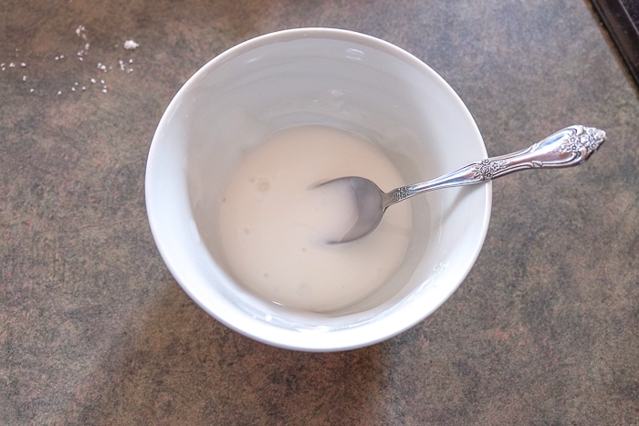 white bowl of sugar icing with spoon inside