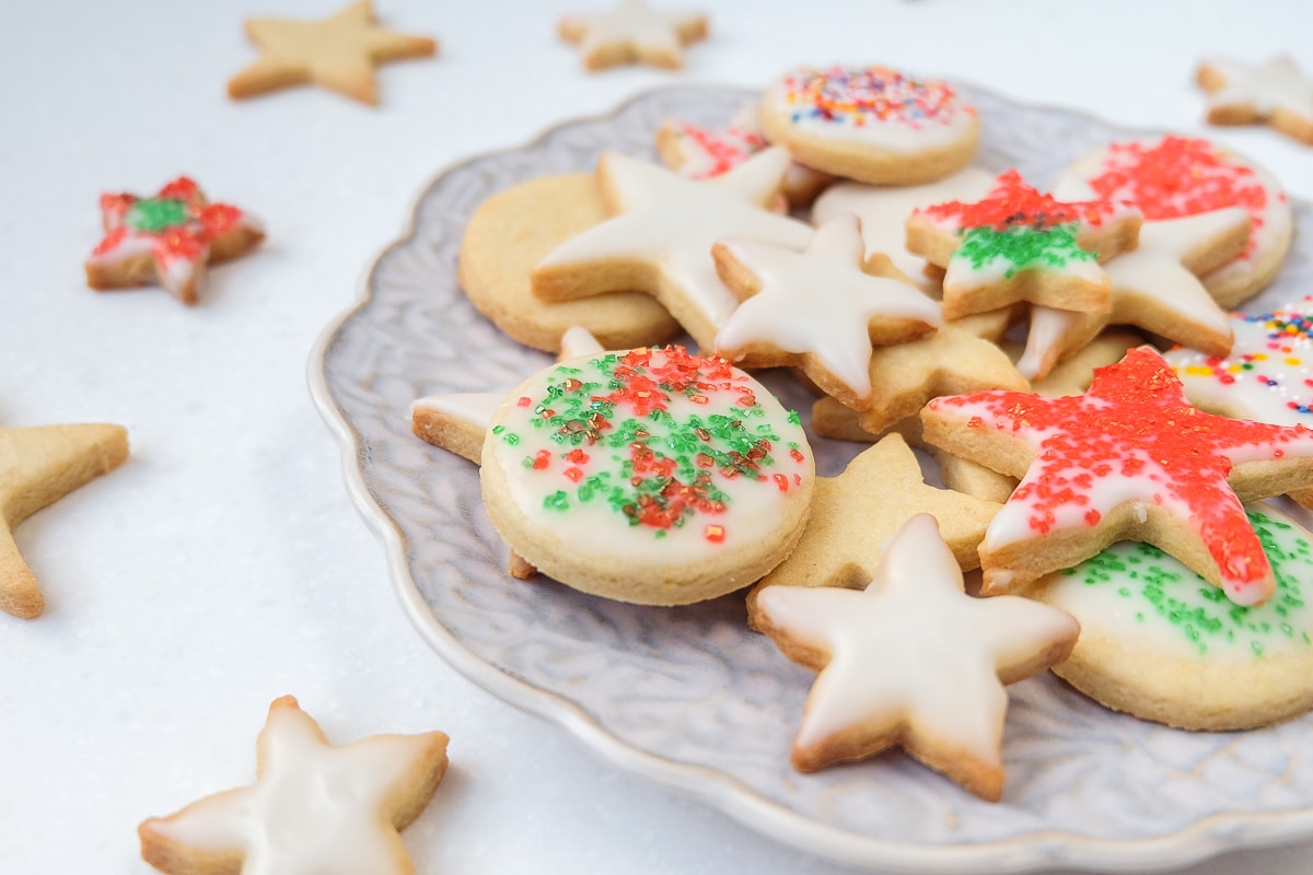 german butter cookies decorated with icing and sprinkles on plate