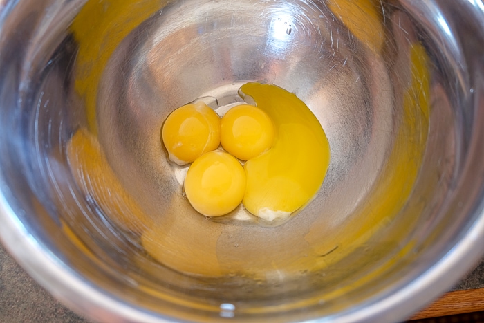 egg yolks in metallic mixing bowl