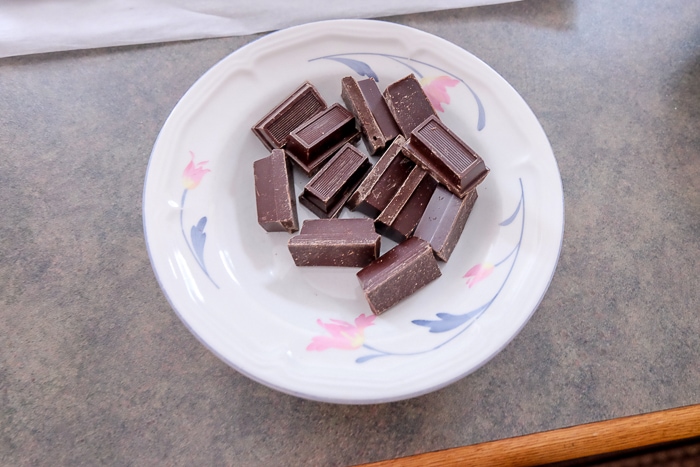 cubes of melting chocolate in white bowl on counter