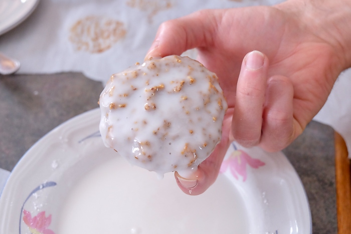 german gingerbread cookie held in hand with white glaze icing
