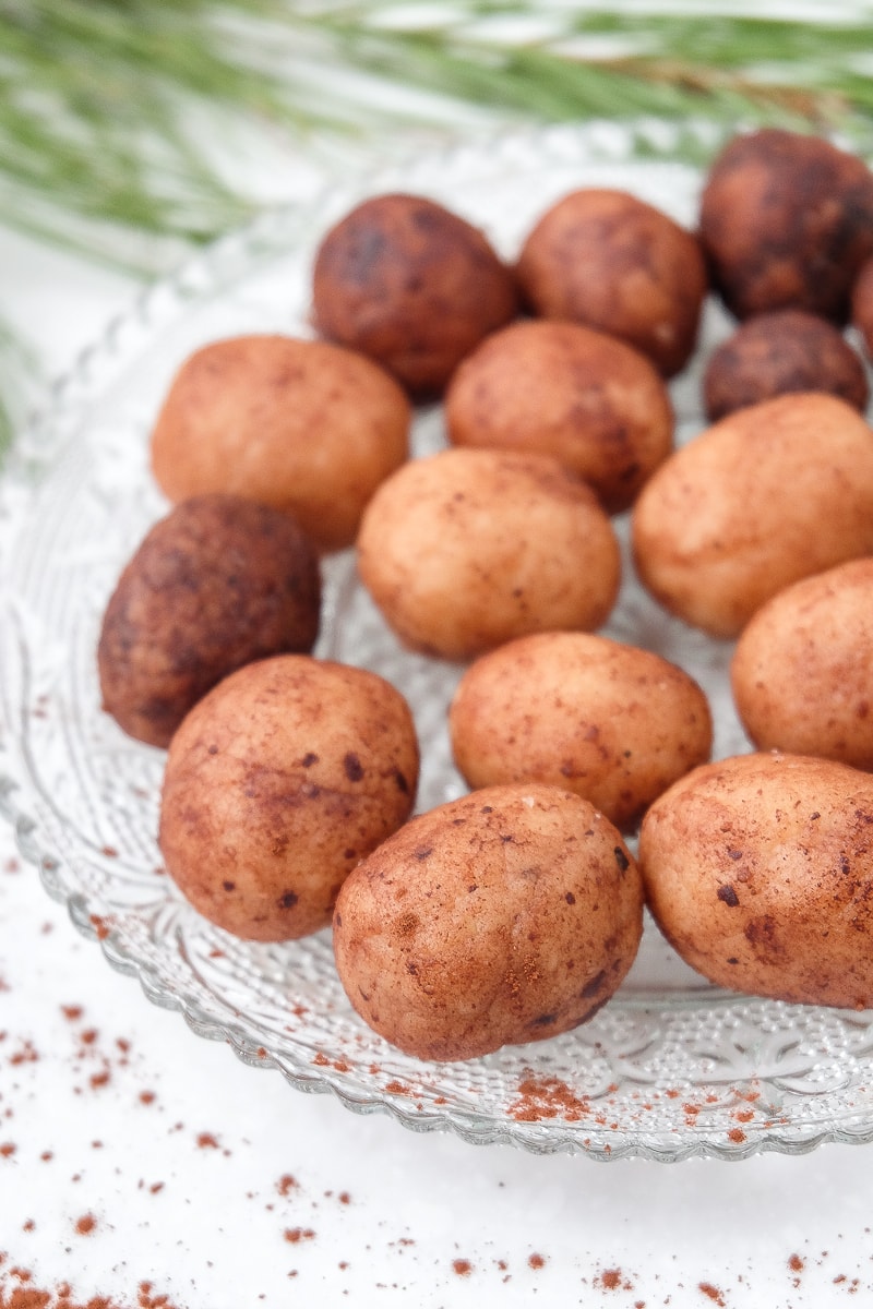 small clear plate of little brown candy potatoes with cocoa powder around