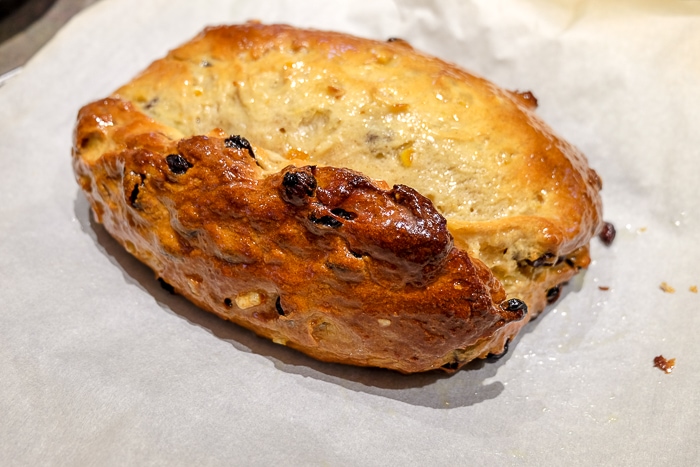 german stollen coated on parchment paper covered in melted butter