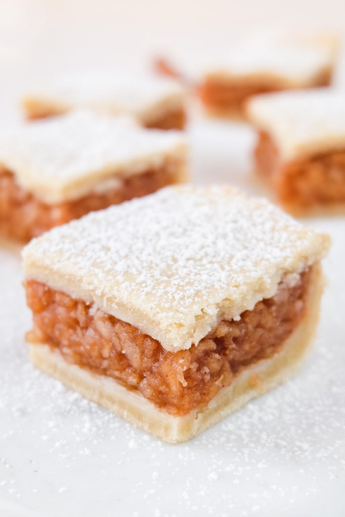 hungarian apple pie square with icing sugar on top on white marble