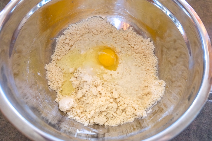 egg in dough in a mixing bowl