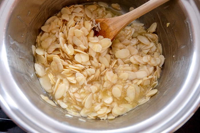 sliced almonds in butter mixture in mixing bowl
