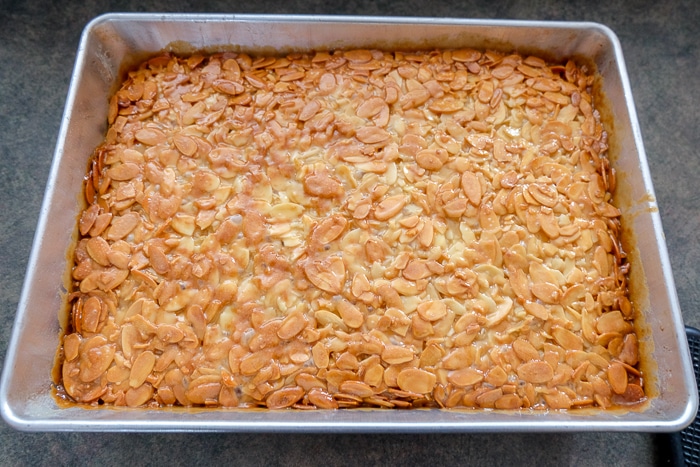 baked Bienenstich cake in silver cake pan on counter top