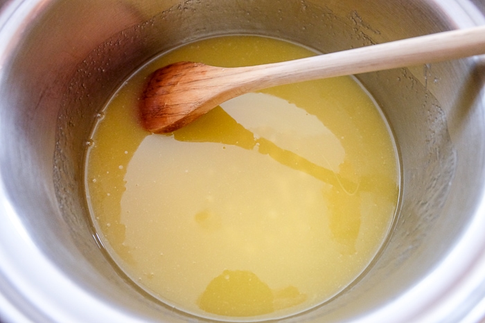 melted butter mixture in bowl stirring with wooden spoon