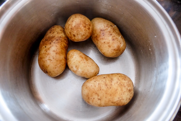 boiled potatoes with skins on in metallic pot