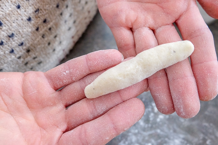 potato noodle dough rolled into noodle shape held in hand