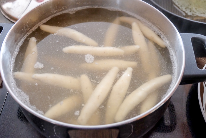 pot of water on stove top with german potato noodles boiling inside
