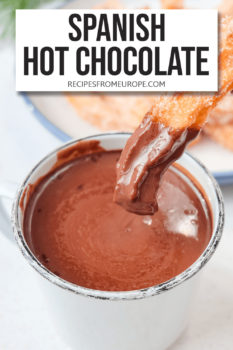 Photo of churro dipped into hot chocolate in mug with text overlay saying Spanish hot chocolate