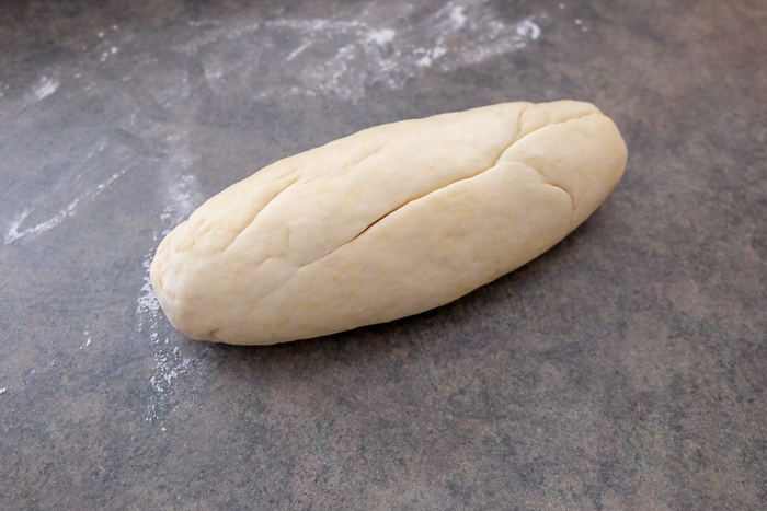 long roll of dough on counter top