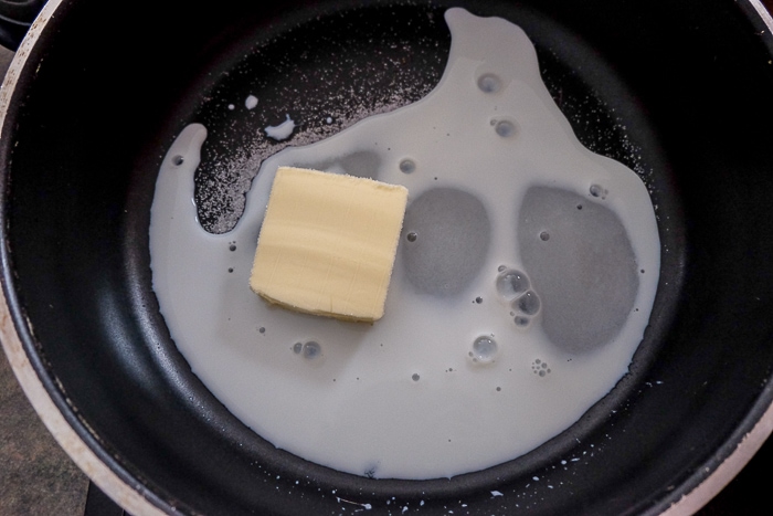 butter in milk in black pan on stove top