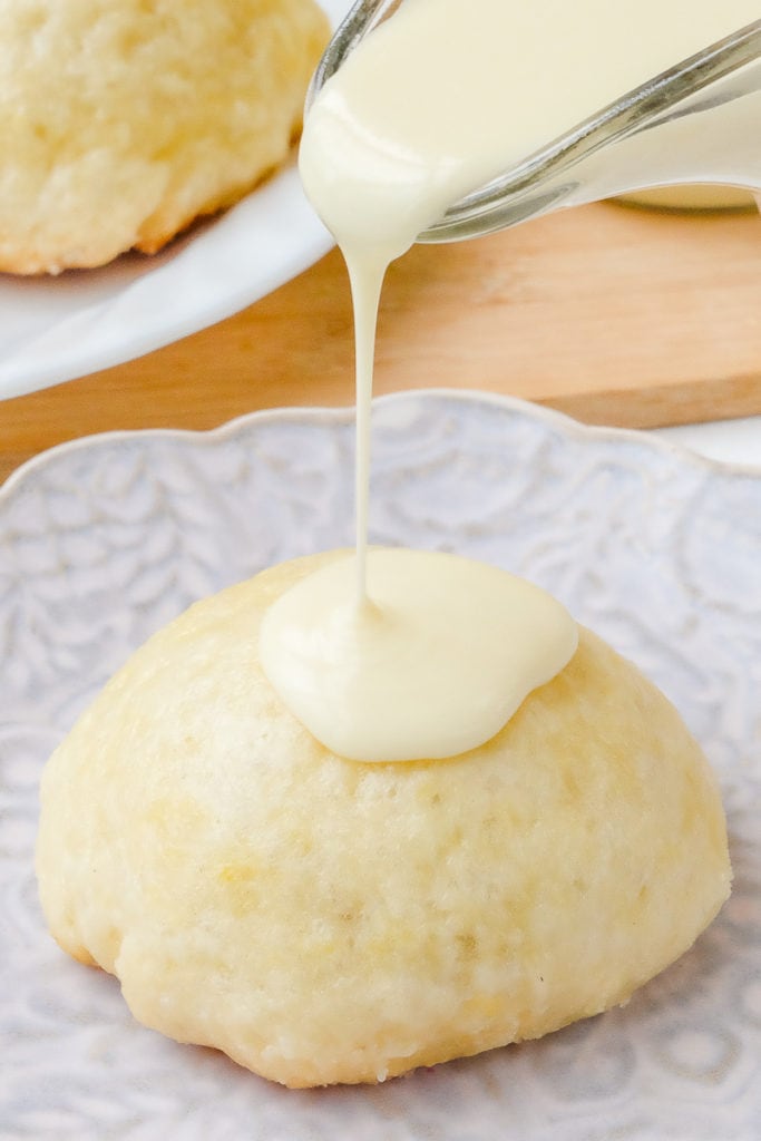 german yeast dumpling on plate with vanilla sauce pouring on top