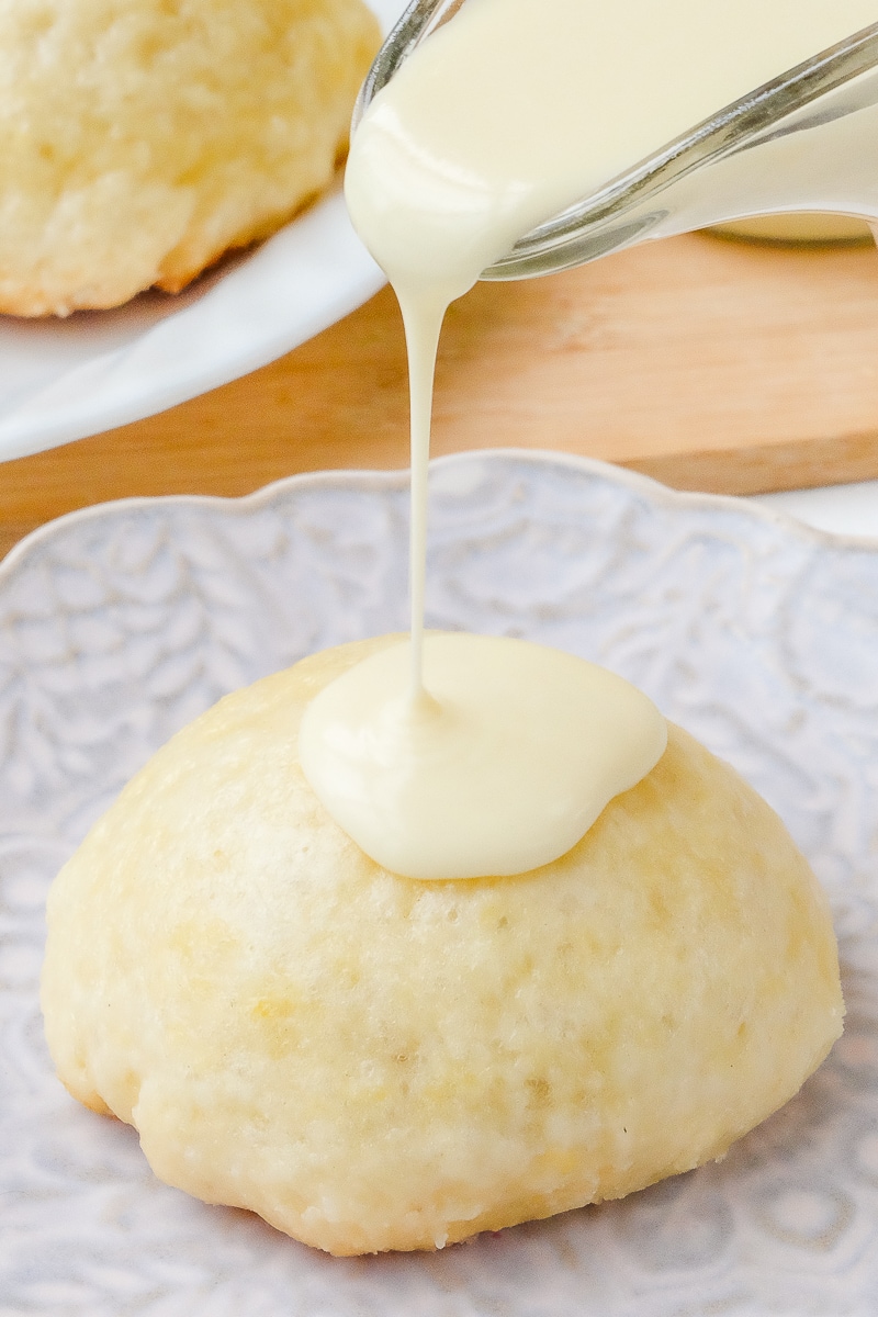 german yeast dumpling on plate with vanilla sauce pouring on top