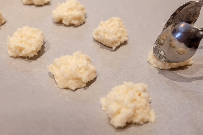 coconut macaroons batter on parchment paper with spoons