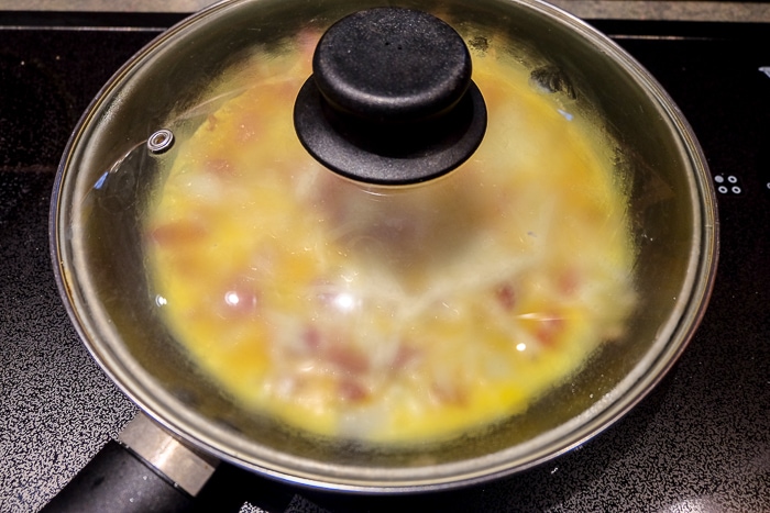 pot lid on frying pan with farmer's omelette inside