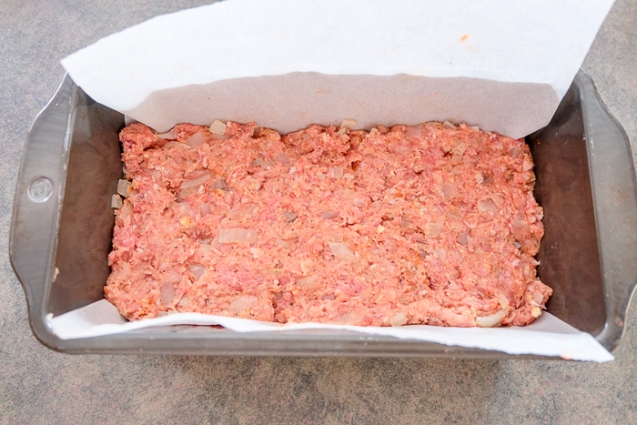 meatloaf raw meat pressed down into loaf pan on counter