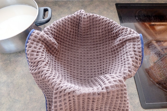 strainer with dish towel inside it on kitchen counter