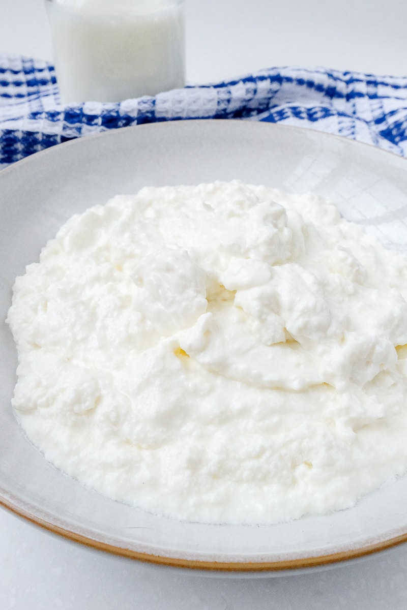 bowl of white german quark with milk and cloth behind