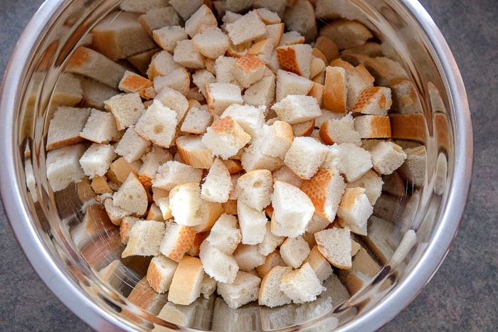 pieces of cut bread in silver mixing bowl for bread dumplings