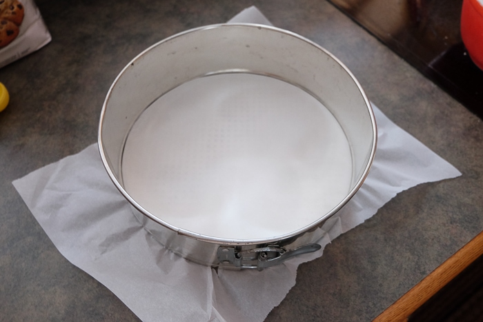 round springform pan with parchment paper on the bottom on counter