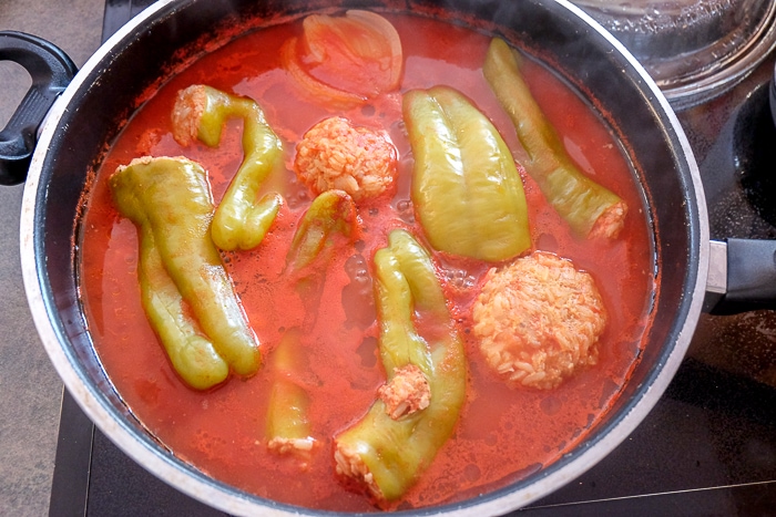 stuffed green peppers in pot with tomato sauce